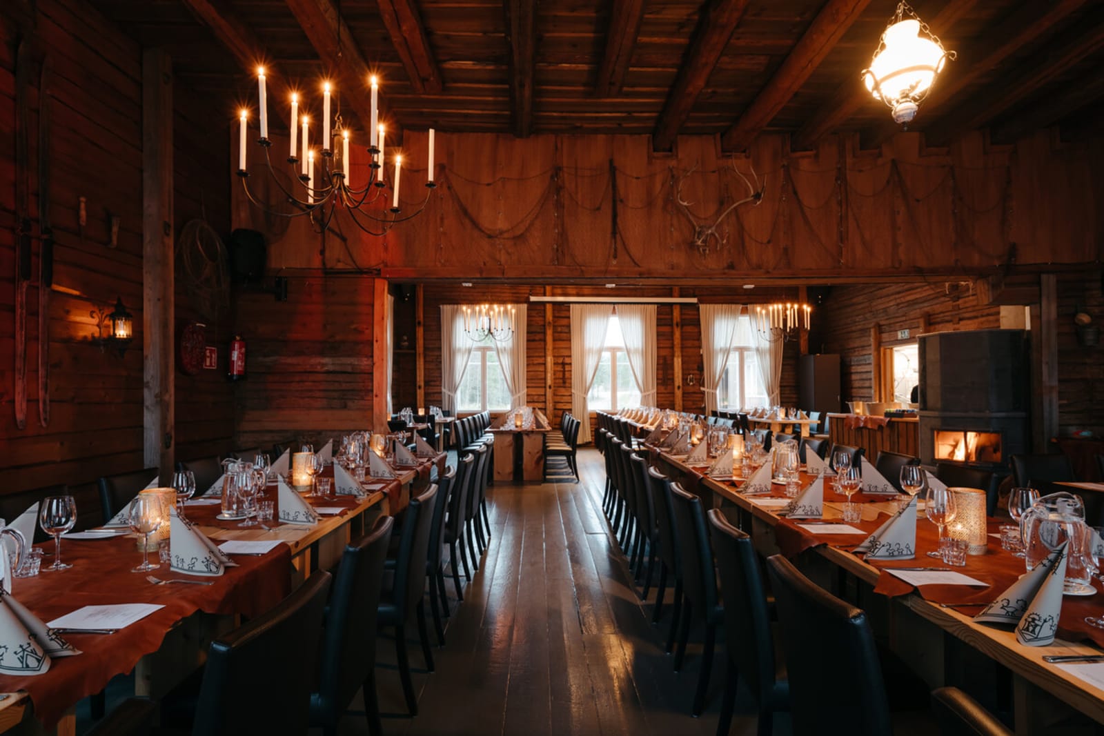 Long candlelit tables inside the Poropirtti log lodge
