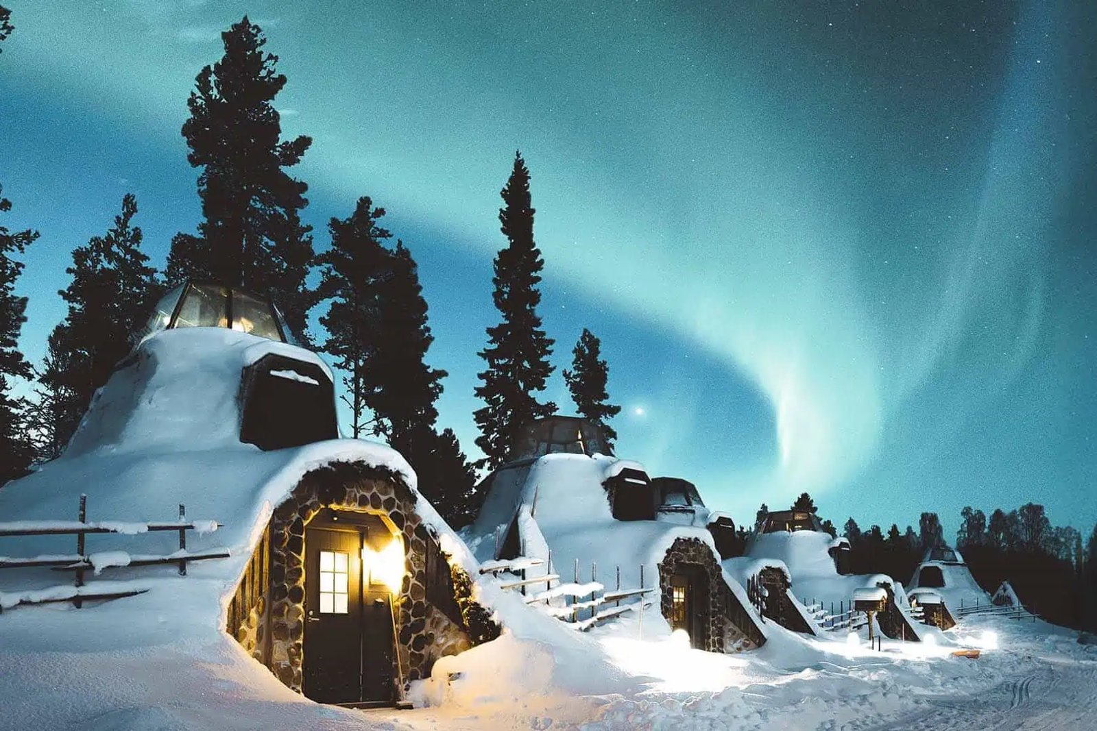 Snow-covered Kammi suites under the aurora