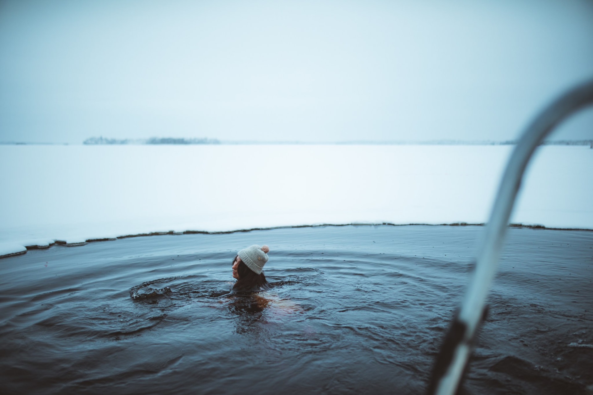 Guest taking an ice-hole dip in a frozen lake