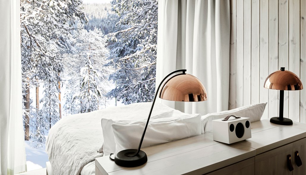 TreeHouse suite with a panoramic window onto snowy forest