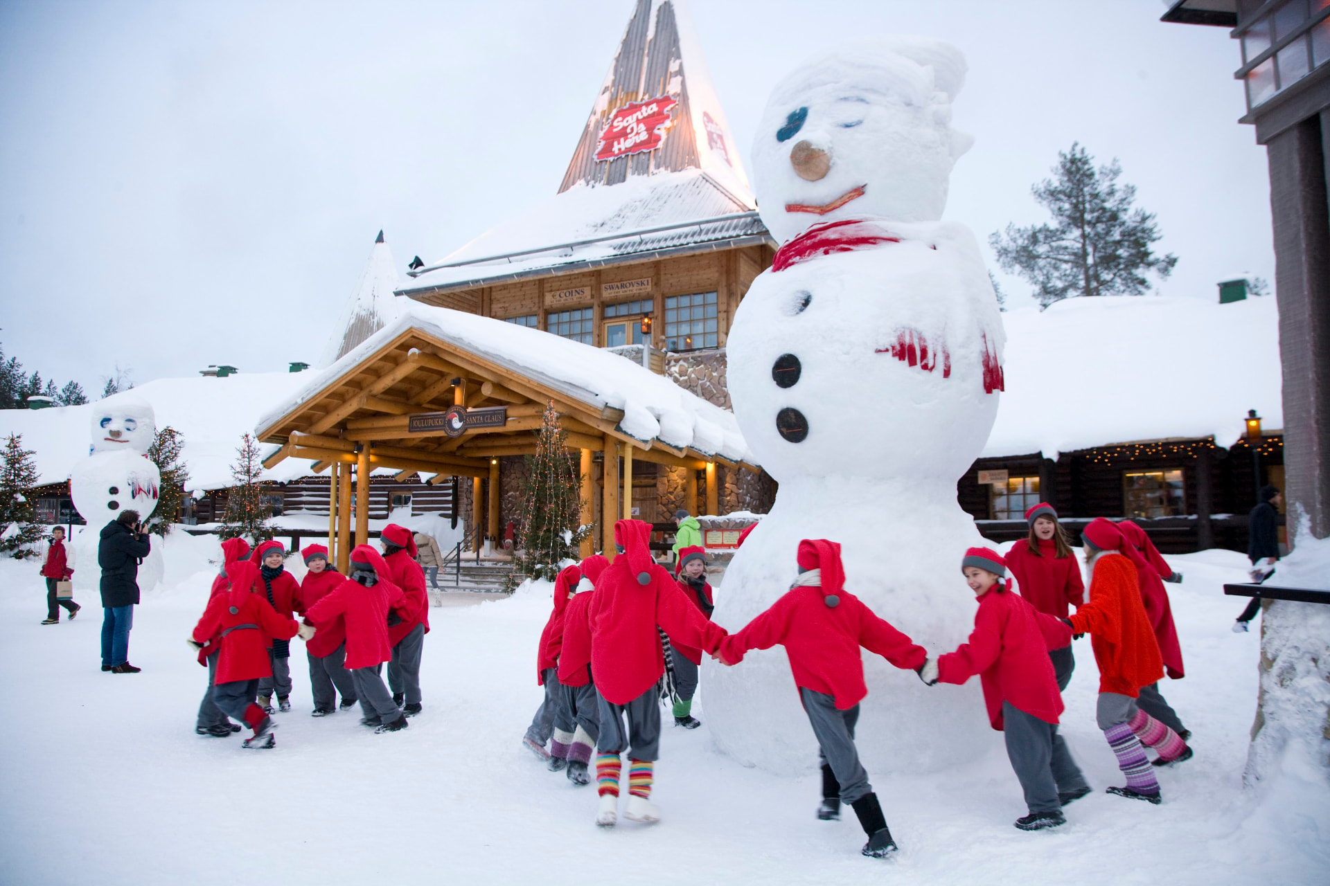 Elves dancing with a snowman at Santa Claus Village